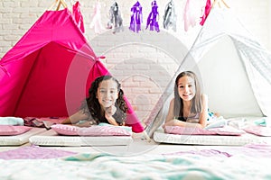 Girls Smiling While Resting In Tipi Tents During Sleepover