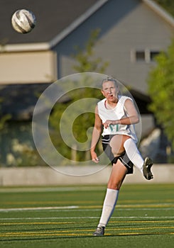 Girls soccer player kicking the ball