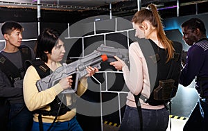 girls standing face to face with laser guns on lasertag gaming arena