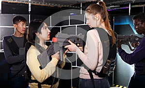 girls standing face to face with laser guns on lasertag gaming arena