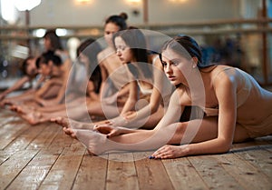 Girls stretch his legs in splits on dance lessons