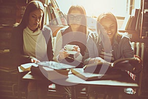 Girls study together in cafe.