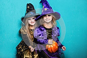 Girls in a suit of a witch. Halloween. Fairy. Tale. Studio portrait on blue background