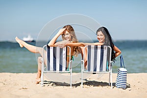 Girls sunbathing on the beach chairs