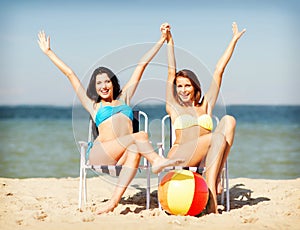 Girls sunbathing on the beach chairs