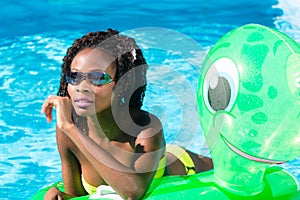 Girls in swimming pool water with inflatable anmimal