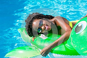 Girls in swimming pool water with inflatable anmimal