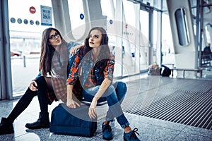 Girls sydt and waiting for your flight with a suitcase.Art proce