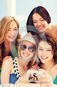 Girls taking photo in cafe on the beach