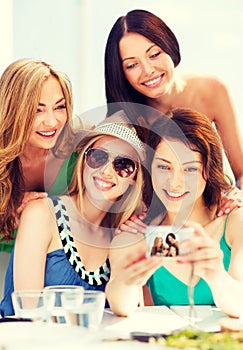 Girls taking photo in cafe on the beach