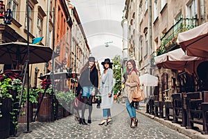 Girls talking and having fun. Outdoor shot of three young women walking on city street