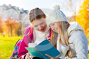 Girls talking looking to textbook