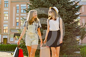 Girls teenagers with shopping bags on city street