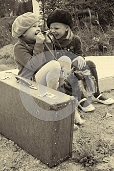 Girls tell each other secrets, sitting at the bus stop