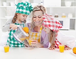 Girls and their mother making fresh fruit juice