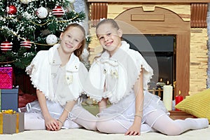 Girls twins with gifts e Christmas tree.