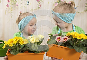 Girls twins of three years care for flowers,