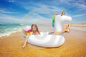 Girls with unicorn buoy on the beach portrait