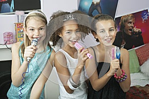 Girls Using Brushes As Microphones At Slumber Party photo