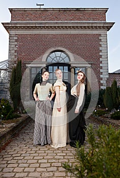 Girls in Victorian in front of old house