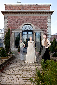 Girls in Victorian in front of old house