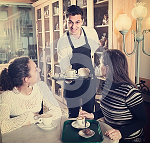 Girls and waiter in coffee-house
