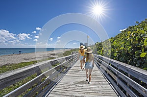 Girls walking on boardwalk on vacation in Florida.