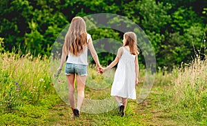 Girls walking dog along ground road