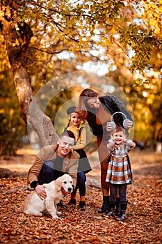 Girls walking Golden Retriever in autumn Park.