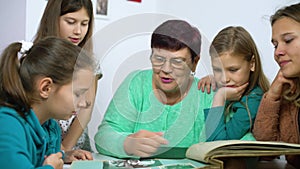 Girls watching old photo album with their grandmother