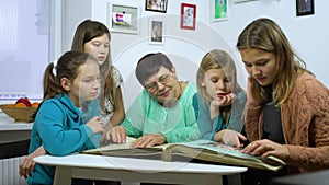 Girls watching old photo album with their grandmother