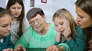 Girls watching old photo album with their grandmother