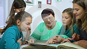 Girls watching old photo album with their grandmother