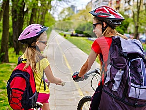 Girls wearing bicycle helmet and rucksack ciclyng .