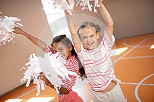 Girls wearing sport clothing laughing while practicing cheerleading