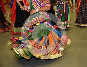 Girls wearing traditional Indian dress performing garba and dandiya dance during Navratri festival Abstract of motion blur effect.