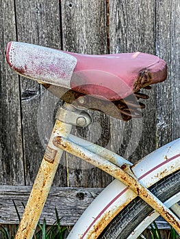 Girls well made vintage, faded leather seat and rust covered wheel and fender, and seat tube