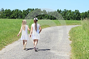 Girls in white dresses on road