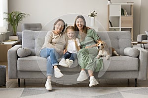 Girls and women of three family generations sitting at dog