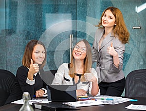 Business girls in office show a gesture of good