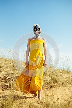 Girls in yellow dress and Gasmask on the sand dunes