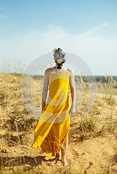 Girls in yellow dress and Gasmask on the sand dunes