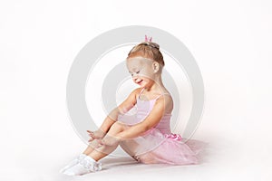 Girls - young ballerinas in pink dresses on a light background