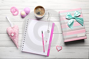 Girly accessories with notebook, cup of coffee and gift box on w