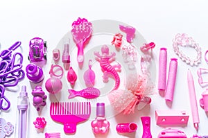 Girly toys for the baby in the pink package. Accessories for dolls. Flat lay