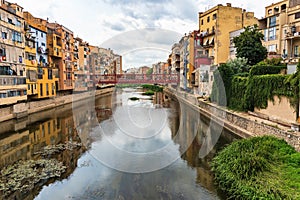 Girona, Spain, August 2018. Beautiful reflection of colorful houses in the dark water of a canal.
