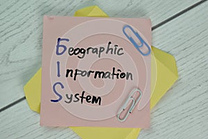 GIS - Geographic Information System write on a book isolated on Wooden Table
