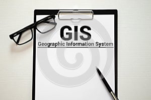 GIS - Geographic Information System write on a book isolated on Wooden Table