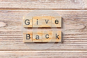 Give Back word written on wood block. Give Back text on table, concept