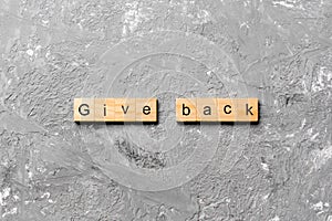 Give Back word written on wood block. Give Back text on table, concept